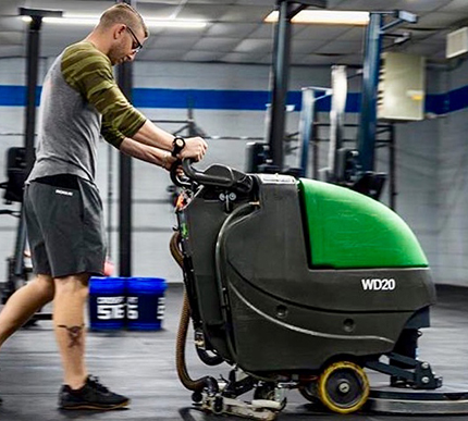 Man using the Bulldog WD20 floor scrubber in a gym