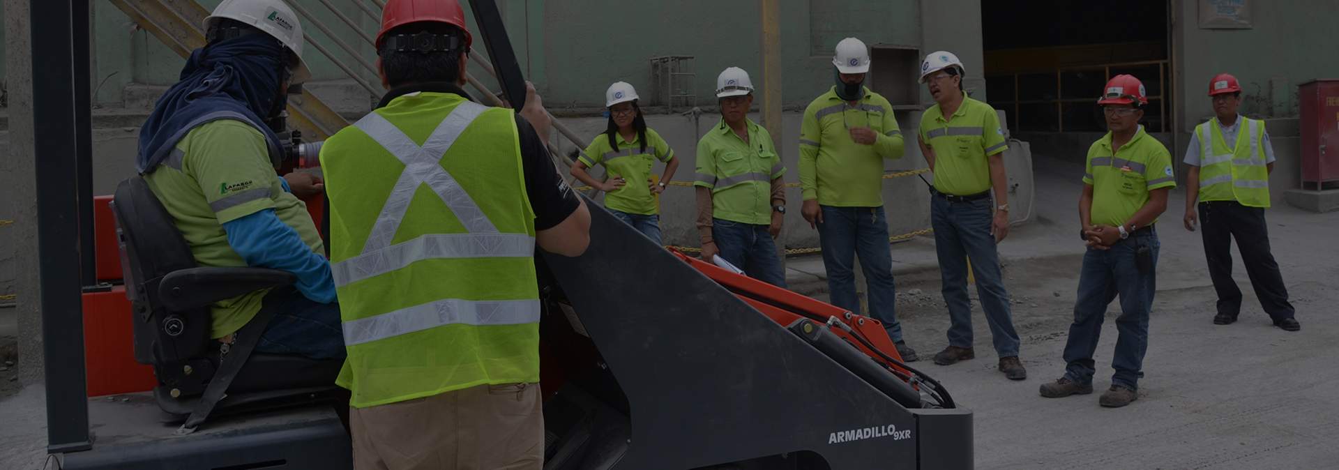 construction workers standing next to a Powerboss Armadillo 9x industrial floor sweeper