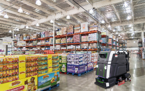 Robotic floor scrubber cleaning polished concrete in a big box retail store