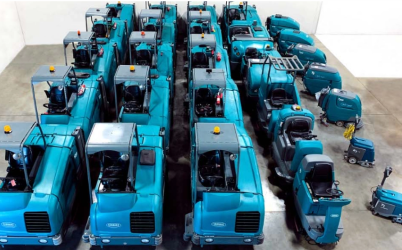 overhead view of Tennant floor scrubbers and sweepers lined up in a warehouse