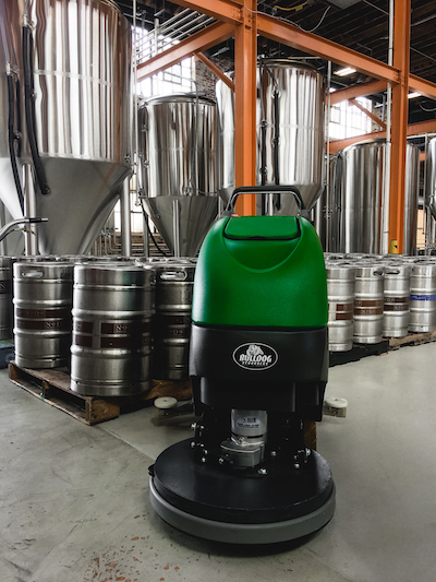 autoscrubber on brewery floor in front of hoppers
