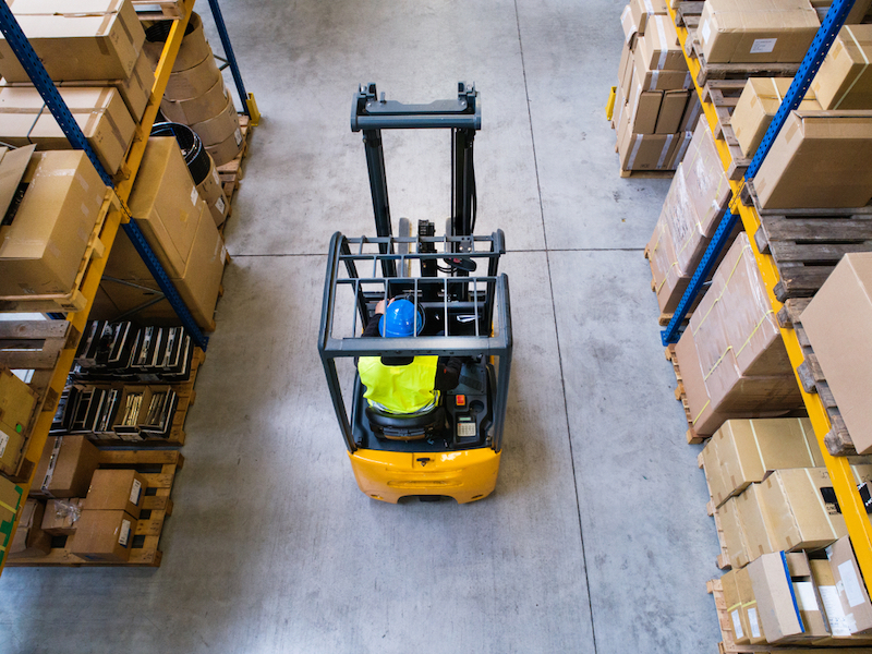 overhead view of forklift on warehouse floor between shelves