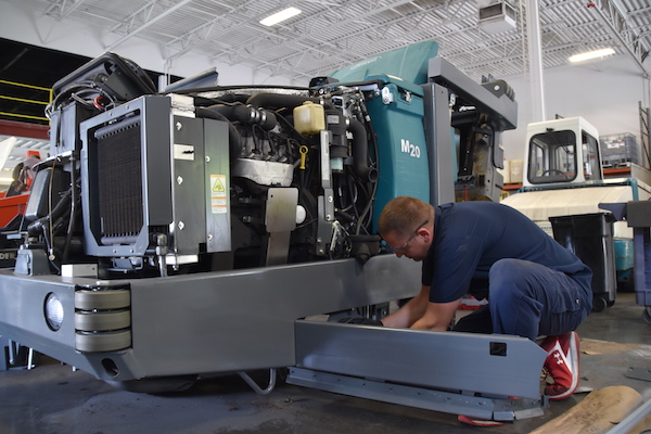 technician repairing tennant m20 industrial floor cleaning machine