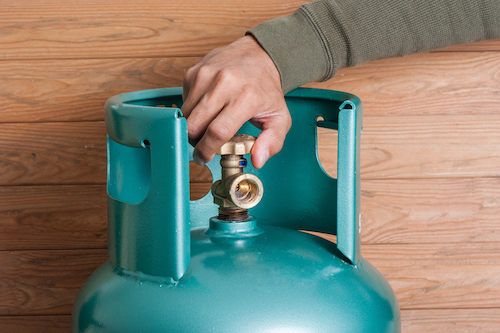 hand opening valve on blue industrial propane tank