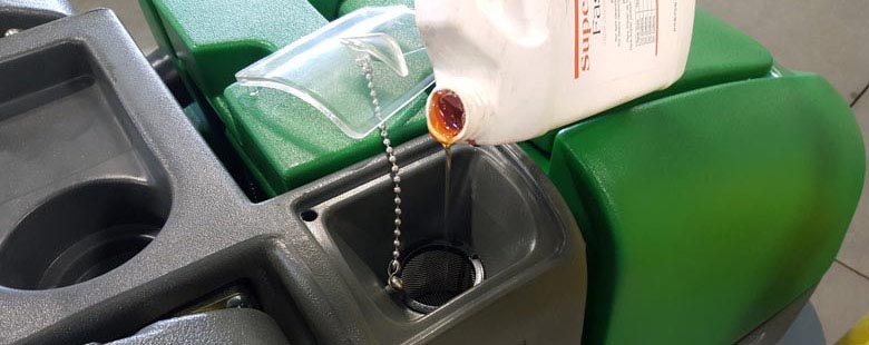 pouring detergent into a floor scrubber